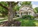 Charming home exterior with a covered front porch, mature tree, and well-manicured lawn at 4818 Winthrop Ave, Indianapolis, IN 46205