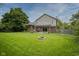 Expansive backyard featuring a fire pit, a well-maintained lawn, and mature trees at 4949 Jennings Dr, Carmel, IN 46033