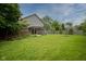 Large, private backyard with lush green grass, a fire pit, and mature trees at 4949 Jennings Dr, Carmel, IN 46033