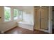 Bright bathroom with a tub, shower, and windows offering a serene view at 4949 Jennings Dr, Carmel, IN 46033