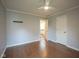 Bedroom with hardwood floors, a ceiling fan, and an open doorway to a bathroom at 4949 Jennings Dr, Carmel, IN 46033