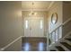 Inviting foyer with hardwood floors, elegant staircase, and stylish light fixture at 4949 Jennings Dr, Carmel, IN 46033