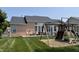 Spacious backyard featuring patio, swing set, lush lawn and the rear of the brick house at 5010 Cabrillo Dr, Plainfield, IN 46168