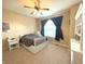 This bedroom features neutral walls, a white-painted bedframe, and a large window dressed with dark curtains at 5010 Cabrillo Dr, Plainfield, IN 46168