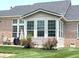 Sunroom with lots of windows, seating, and adjacent brick patio, all surrounded by green grass at 5010 Cabrillo Dr, Plainfield, IN 46168