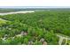 Aerial shot showcases a home nestled among trees near Eagle Creek Park and a main road at 5558 Spicebush Dr, Indianapolis, IN 46254