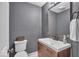 Modern bathroom with gray walls and a wooden vanity offering a sink and toilet at 5558 Spicebush Dr, Indianapolis, IN 46254