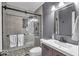 Modern bathroom with a glass-enclosed shower featuring gray tile, stone floor, and sleek fixtures at 5558 Spicebush Dr, Indianapolis, IN 46254
