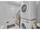 Bright laundry area featuring a stacked washer and dryer, and a door to the side yard at 5558 Spicebush Dr, Indianapolis, IN 46254
