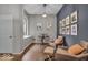Comfortable seating area with leather chairs, hardwood floors, and natural light from a large window at 5558 Spicebush Dr, Indianapolis, IN 46254
