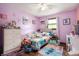 Cozy bedroom features purple walls, wood floors, and a well-lit window at 5631 N Olivia Dr, Alexandria, IN 46001