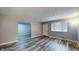 Open living room with light grey walls, large window, and contemporary vinyl flooring at 5806 E 19Th St, Indianapolis, IN 46218