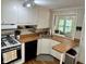Charming kitchen with white cabinets, wood countertops, and a view to the outside through a window at 5889 Crestview Ave, Indianapolis, IN 46220
