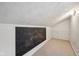 Finished attic space with carpeted floors, chalkboard, storage racks, and unique architectural ceiling at 604 Alexandria Pike, Anderson, IN 46012