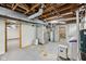 Unfinished basement with exposed wood beams, and utility equipment including water heaters at 604 Alexandria Pike, Anderson, IN 46012