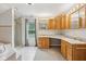 Bright bathroom featuring double sinks, oak cabinets, tub and shower at 604 Alexandria Pike, Anderson, IN 46012
