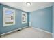 Serene blue bedroom featuring two windows, carpeted floors, and neutral trim, an inviting space for restful nights at 604 Alexandria Pike, Anderson, IN 46012