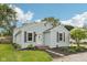 Cozy single-story home showcases light blue siding and well-kept front garden under a sunny blue sky at 604 Alexandria Pike, Anderson, IN 46012