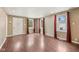 Hardwood floors, three windows, and a large door opening into a sunlit space grace this inviting living room at 604 Alexandria Pike, Anderson, IN 46012