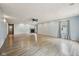 Spacious living room with light blue walls, wood-look floors, a ceiling fan, and a cozy fireplace with a tiled surround at 604 Alexandria Pike, Anderson, IN 46012