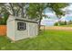 Charming backyard shed with wooden siding and a double door in a serene landscape at 604 Alexandria Pike, Anderson, IN 46012