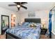 This bedroom features a ceiling fan, blue quilt, and view to bathroom at 6553 Black Antler Dr, Indianapolis, IN 46217