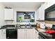 Kitchen with black appliances, a double sink, and white cabinets at 6553 Black Antler Dr, Indianapolis, IN 46217