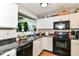 Kitchen with black appliances, light cabinets, and a view to the living room at 6553 Black Antler Dr, Indianapolis, IN 46217
