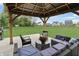 Relaxing backyard patio features comfortable seating under a wooden pergola overlooking the expansive lawn at 6917 Wolf Creek Ct, Whitestown, IN 46075