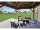 Relaxing backyard patio features comfortable seating under a wooden pergola overlooking the expansive lawn at 6917 Wolf Creek Ct, Whitestown, IN 46075