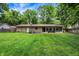 Expansive backyard with lush green grass and a stone exterior, ideal for outdoor activities at 741 Fairway Dr, Indianapolis, IN 46260