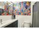 Stylish bathroom with eye-catching floral wallpaper, white tiling and black vanity at 741 Fairway Dr, Indianapolis, IN 46260