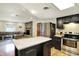 Kitchen flows into living room with breakfast bar, fireplace, stainless appliances, and granite countertops at 741 Fairway Dr, Indianapolis, IN 46260