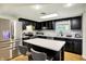Modern kitchen with stainless-steel appliances, dark cabinetry, white countertops, and an island with seating at 741 Fairway Dr, Indianapolis, IN 46260