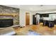 Open concept living room flows into the kitchen, featuring wood floors, a fireplace, and stainless-steel appliances at 741 Fairway Dr, Indianapolis, IN 46260