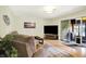 Comfortable living area features a sliding glass door to a sunroom, a large TV, and cozy seating at 741 Fairway Dr, Indianapolis, IN 46260