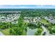 Aerial view of houses with ponds surrounded by lush greenery and tree-lined streets on a sunny day at 7521 Kilbarron Cir, Indianapolis, IN 46217