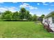 Lush backyard with mature trees, a patio, and an irrigation system for easy maintenance at 7521 Kilbarron Cir, Indianapolis, IN 46217