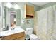 Well-lit bathroom with a wood vanity, floral shower curtain, and a medicine cabinet at 7521 Kilbarron Cir, Indianapolis, IN 46217