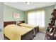 Cozy bedroom with twin beds, soft green walls, and natural light from a large window at 7521 Kilbarron Cir, Indianapolis, IN 46217