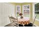 Cozy dining nook with natural light from windows, white chairs, and a checkered tablecloth at 7521 Kilbarron Cir, Indianapolis, IN 46217