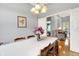 Dining room features a long table with chandelier lighting, view to living room, and backyard at 7521 Kilbarron Cir, Indianapolis, IN 46217