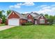 Charming single-story red brick home featuring an attached two-car garage and lush green lawn at 7521 Kilbarron Cir, Indianapolis, IN 46217