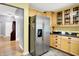 Kitchen featuring stainless steel refrigerator, wood cabinets, and view into dining room at 7521 Kilbarron Cir, Indianapolis, IN 46217