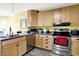Bright kitchen with stainless steel appliances, wood cabinets, and gray countertops at 7521 Kilbarron Cir, Indianapolis, IN 46217