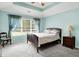 Relaxing bedroom with tray ceilings, natural light from a large window, and neutral carpeting at 7521 Kilbarron Cir, Indianapolis, IN 46217