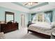 Serene bedroom with tray ceiling, large window, and view of the ensuite bathroom at 7521 Kilbarron Cir, Indianapolis, IN 46217