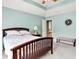 Relaxing bedroom with tray ceiling, neutral carpet, and view into hallway at 7521 Kilbarron Cir, Indianapolis, IN 46217