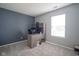 Bedroom with a gray accent wall, desk, and gray carpet at 7724 Blackthorn Dr, Indianapolis, IN 46236