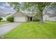 Charming brick home featuring a well-maintained lawn and mature tree, enhancing its curb appeal at 7724 Blackthorn Dr, Indianapolis, IN 46236